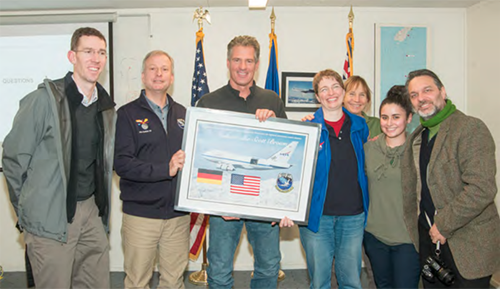 Ambassador Brown receiving a signed lithograph with a flag that was flown on SOFIA