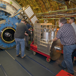 NASA and German scientists and technicians move the GREAT instrument near the Stratospheric Observatory for Infrared Astronomy's telescope prior to mounting.