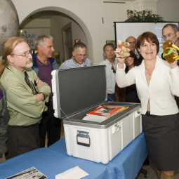 Former mission director Wendy Dolci holds up two mascots from the Kuiper Airborne Observatory during the KAO time capsule opening ceremony on Nov. 10, 2010.